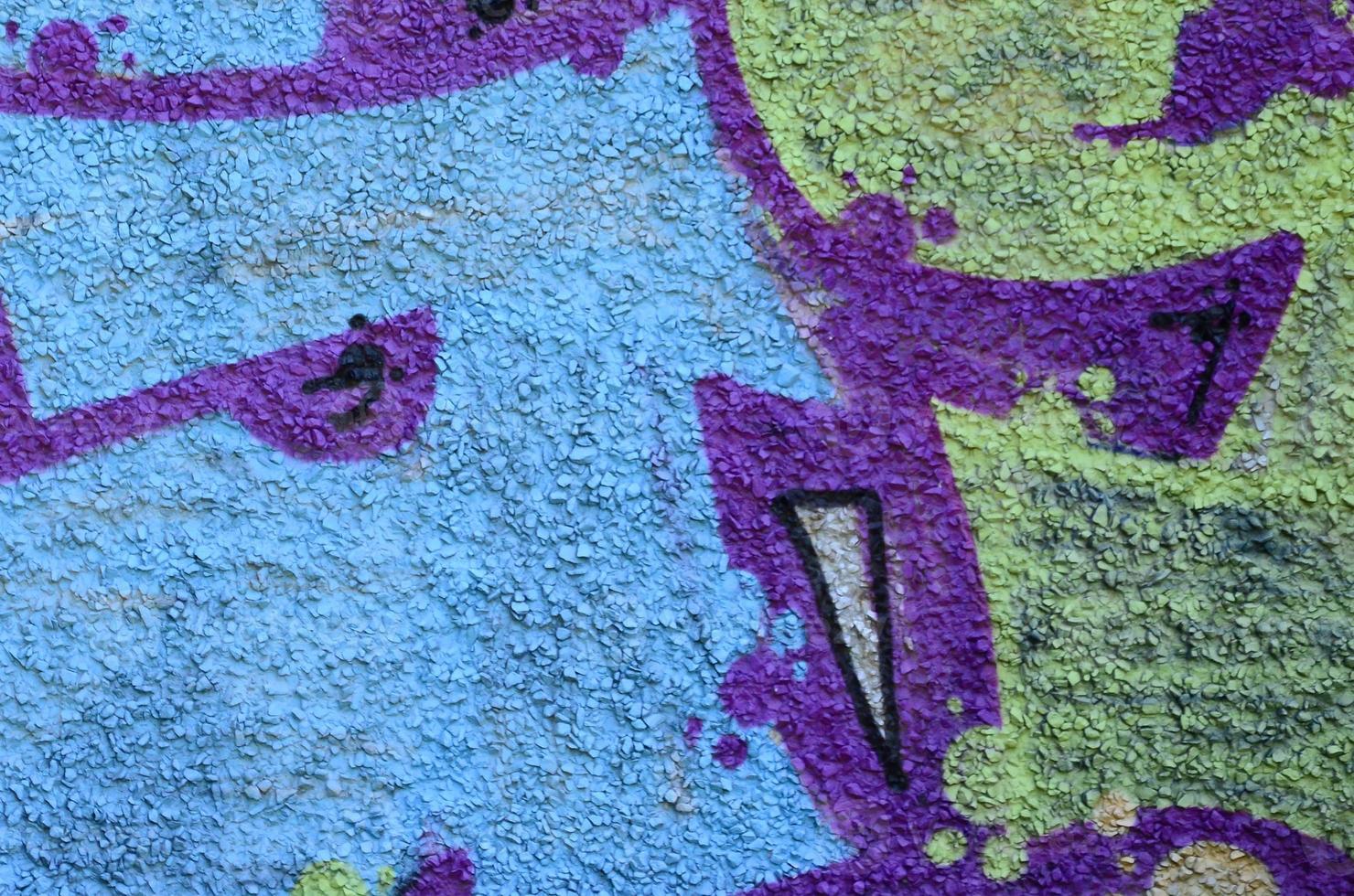 Fragment of graffiti drawings. The old wall decorated with paint stains in the style of street art culture. Colored background texture in warm tones photo