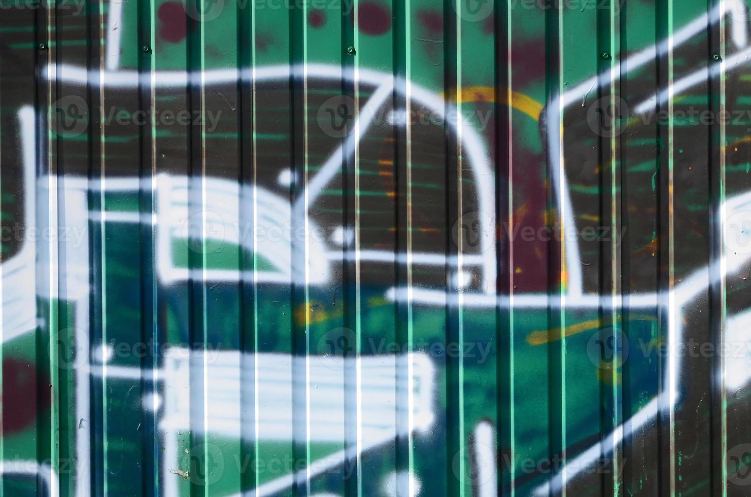 Fragment of graffiti drawings. The old wall decorated with paint stains in the style of street art culture. Colored background texture in green tones photo
