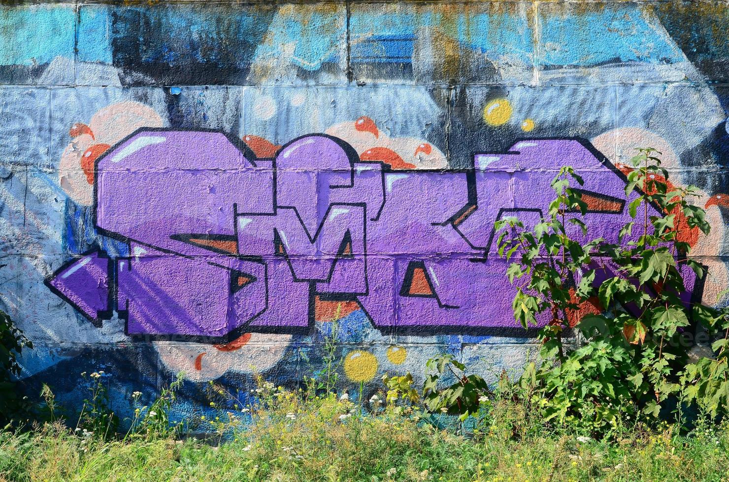 Fragment of graffiti drawings. The old wall decorated with paint stains in the style of street art culture. Colored background texture in purple tones photo