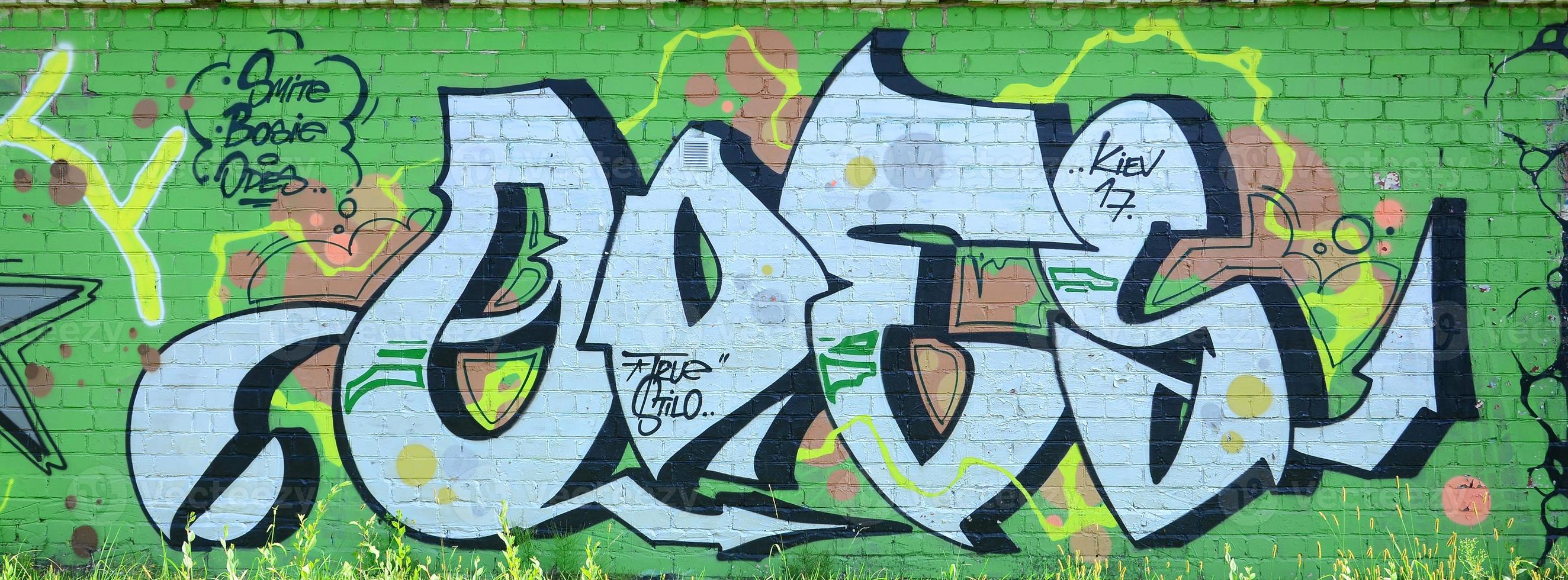 Fragment of graffiti drawings. The old wall decorated with paint stains in the style of street art culture. Colored background texture in green tones photo