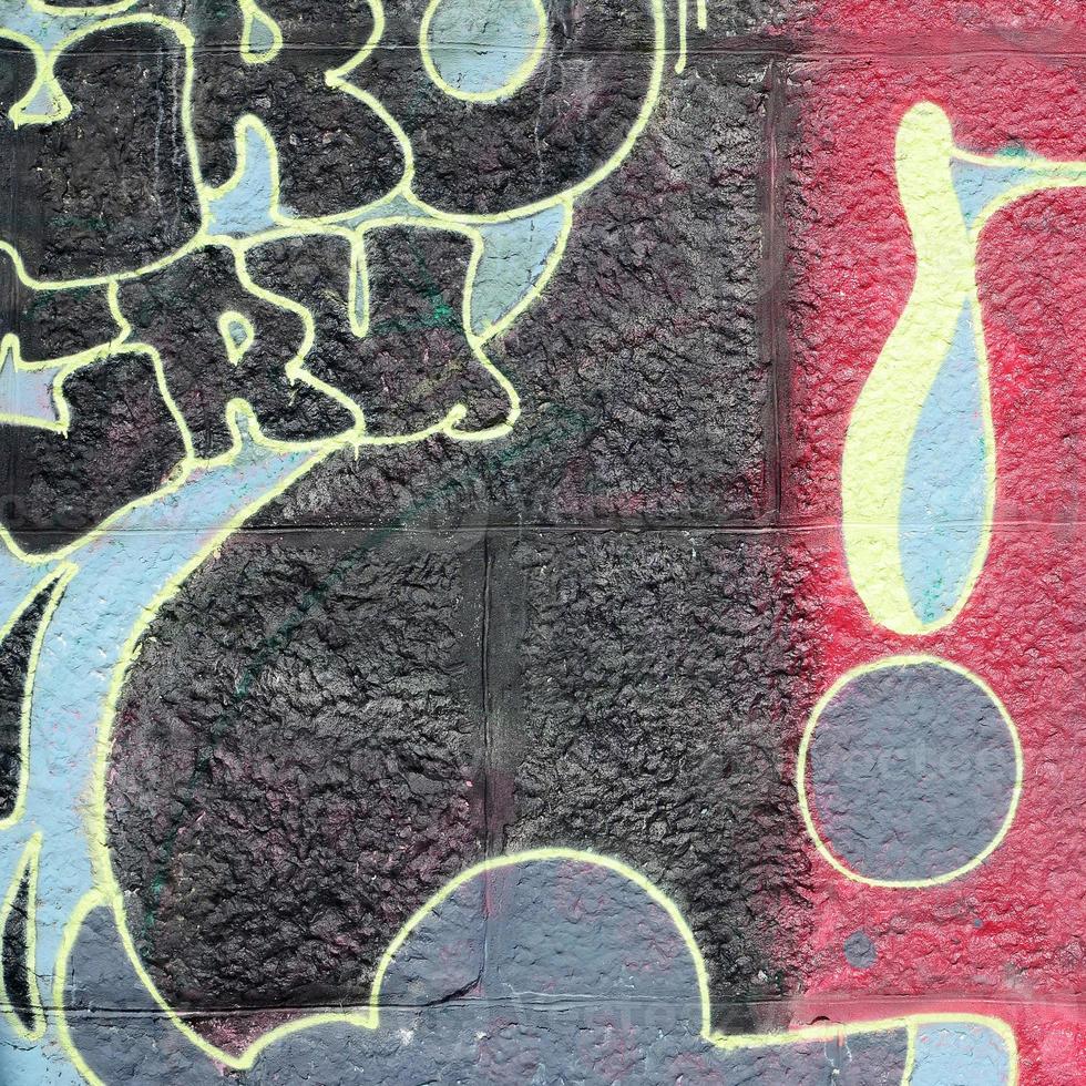 Fragment of graffiti drawings. The old wall decorated with paint stains in the style of street art culture. Multicolored background texture photo