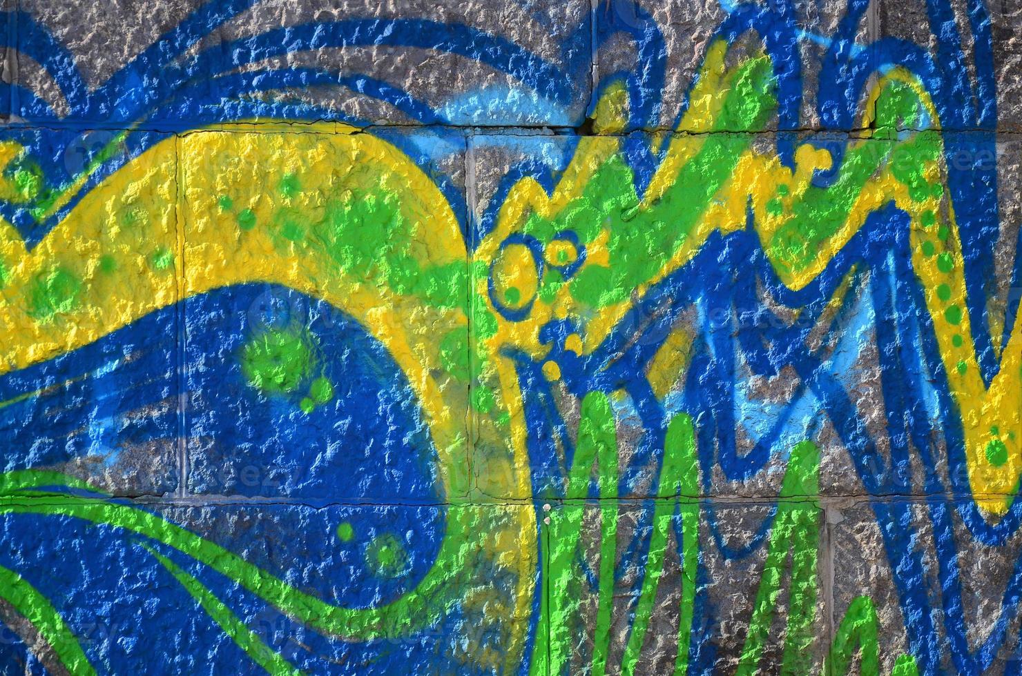 Fragment of graffiti drawings. The old wall decorated with paint stains in the style of street art culture. Colored background texture in green tones photo