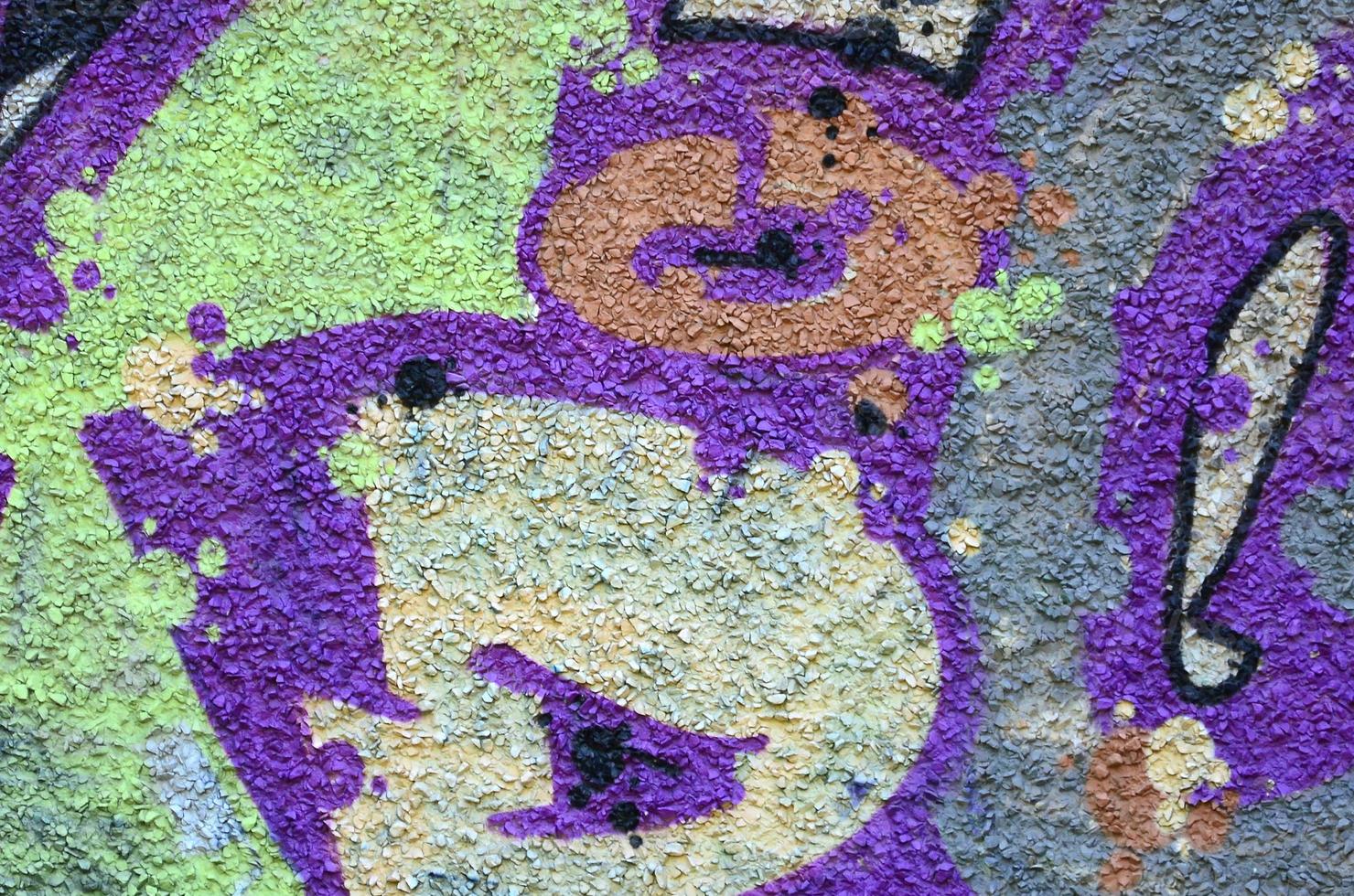 Fragment of graffiti drawings. The old wall decorated with paint stains in the style of street art culture. Colored background texture in warm tones photo