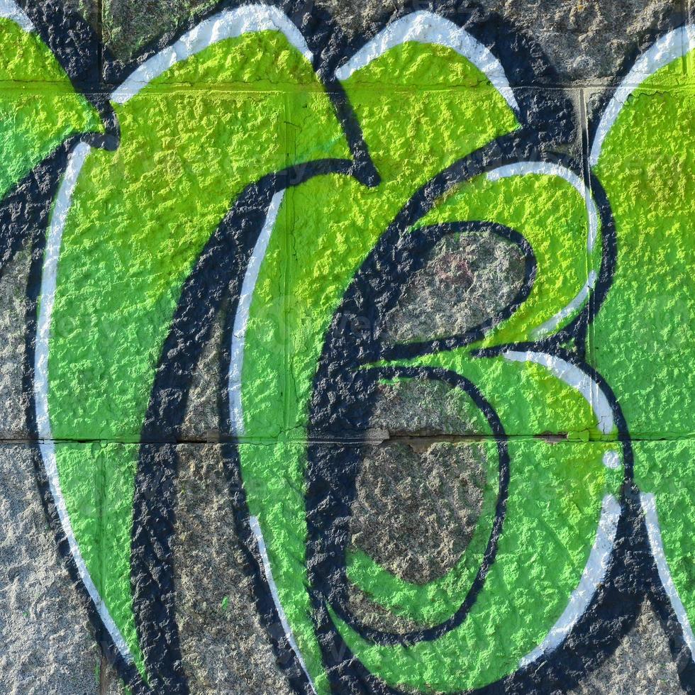 Fragment of graffiti drawings. The old wall decorated with paint stains in the style of street art culture. Colored background texture in green tones photo