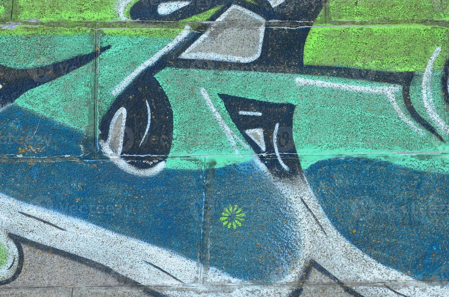 Fragment of graffiti drawings. The old wall decorated with paint stains in the style of street art culture. Colored background texture in green tones photo