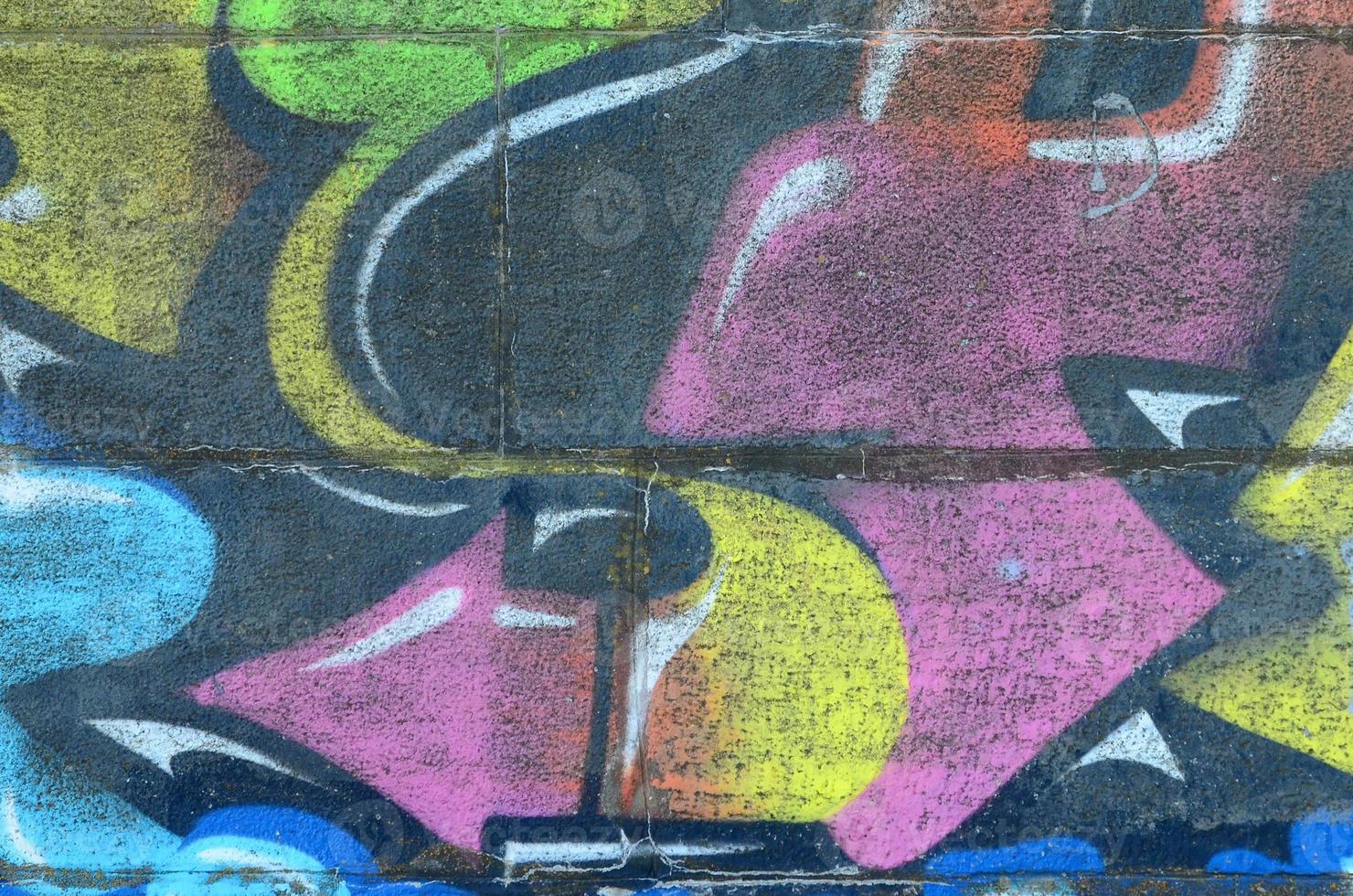 Fragment of graffiti drawings. The old wall decorated with paint stains in the style of street art culture. Multicolored background texture photo