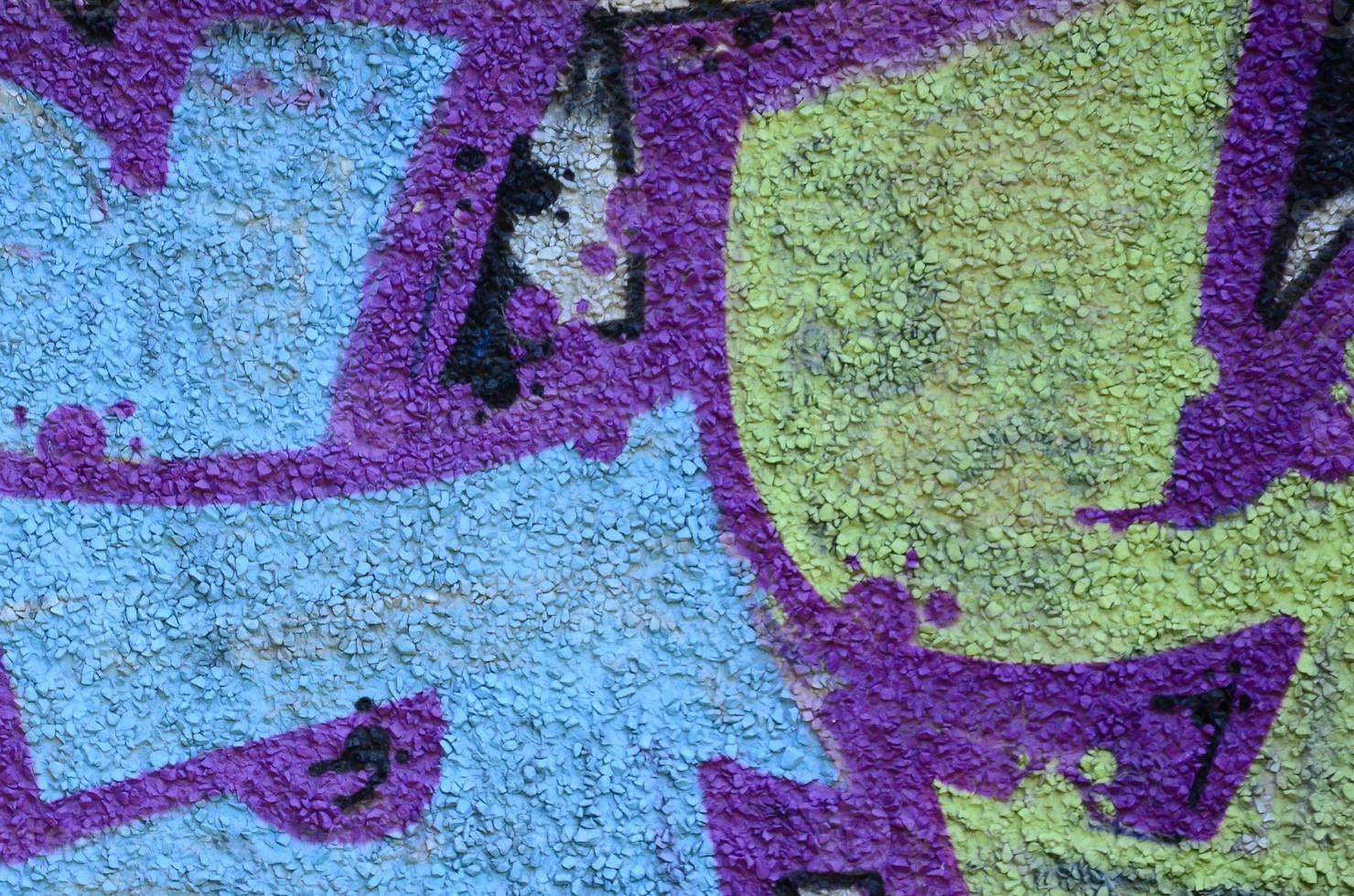 Fragment of graffiti drawings. The old wall decorated with paint stains in the style of street art culture. Colored background texture in warm tones photo