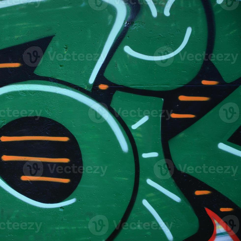 Fragment of graffiti drawings. The old wall decorated with paint stains in the style of street art culture. Colored background texture in green tones photo