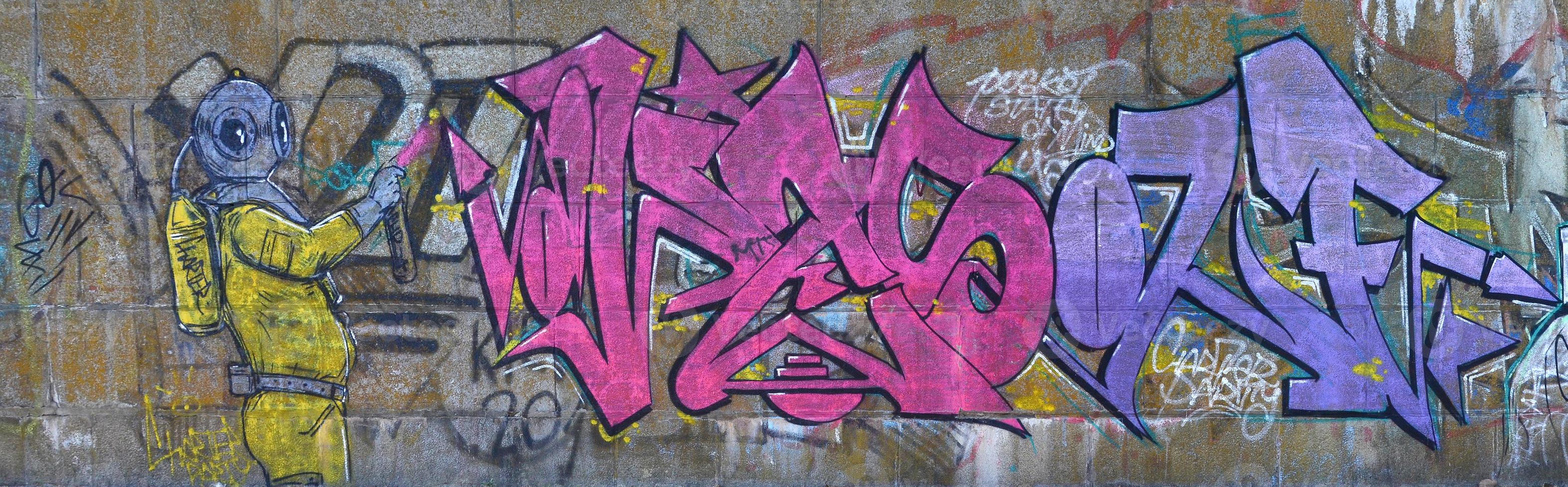 fragmento de dibujos de graffiti. la antigua muralla decorada con manchas de pintura al estilo de la cultura del arte callejero. buzo de miedo foto