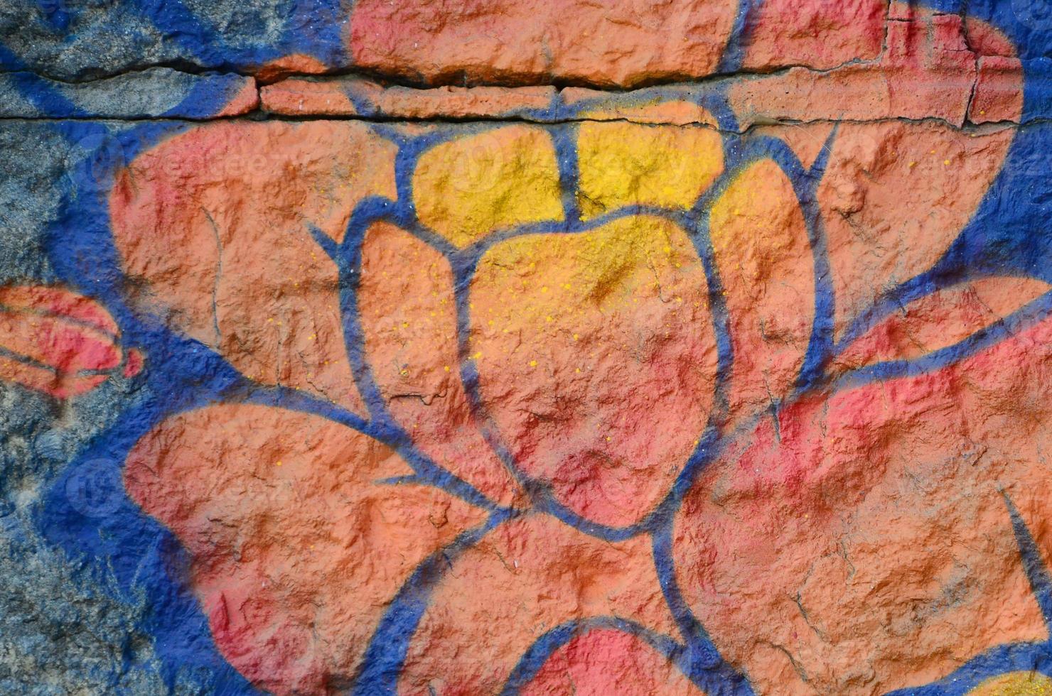 Fragment of graffiti drawings. The old wall decorated with paint stains in the style of street art culture. Orange flower photo