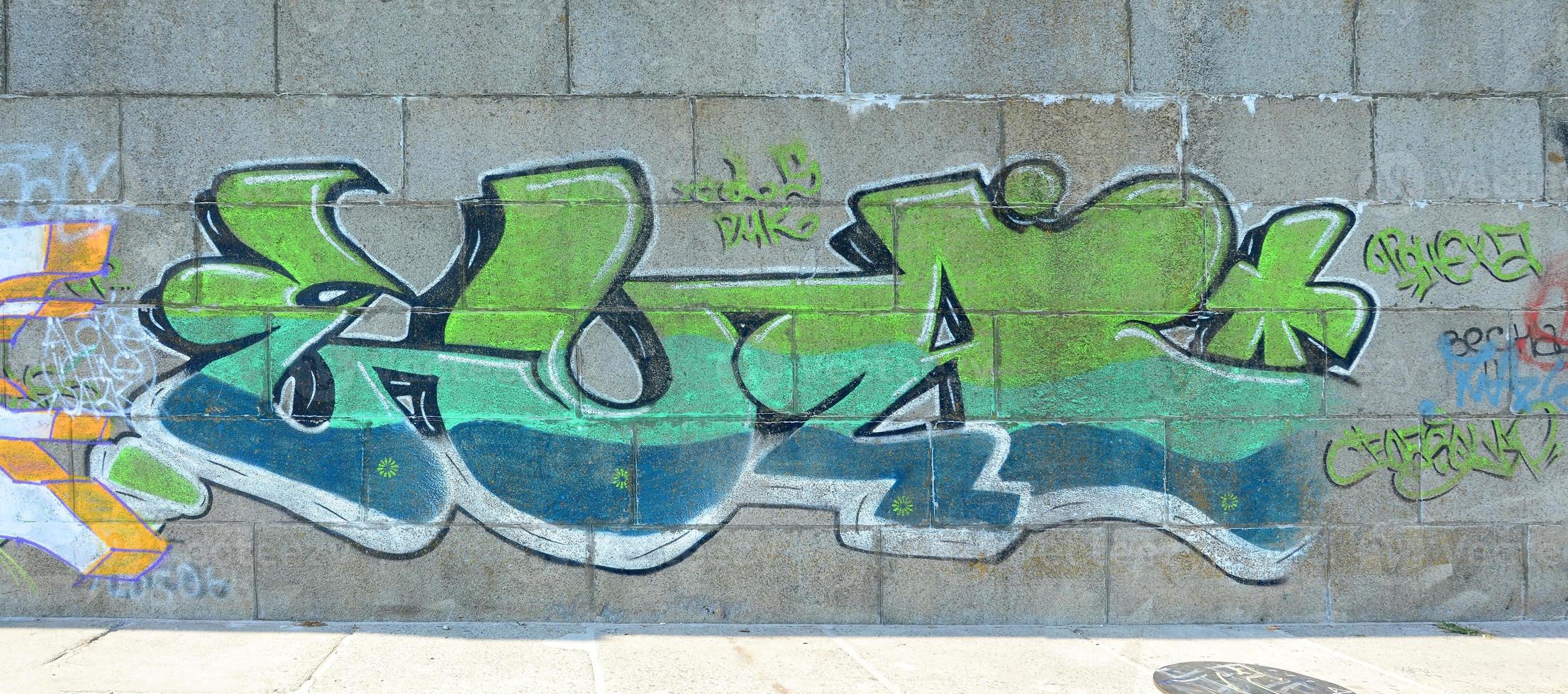 Fragment of graffiti drawings. The old wall decorated with paint stains in the style of street art culture. Colored background texture in green tones photo