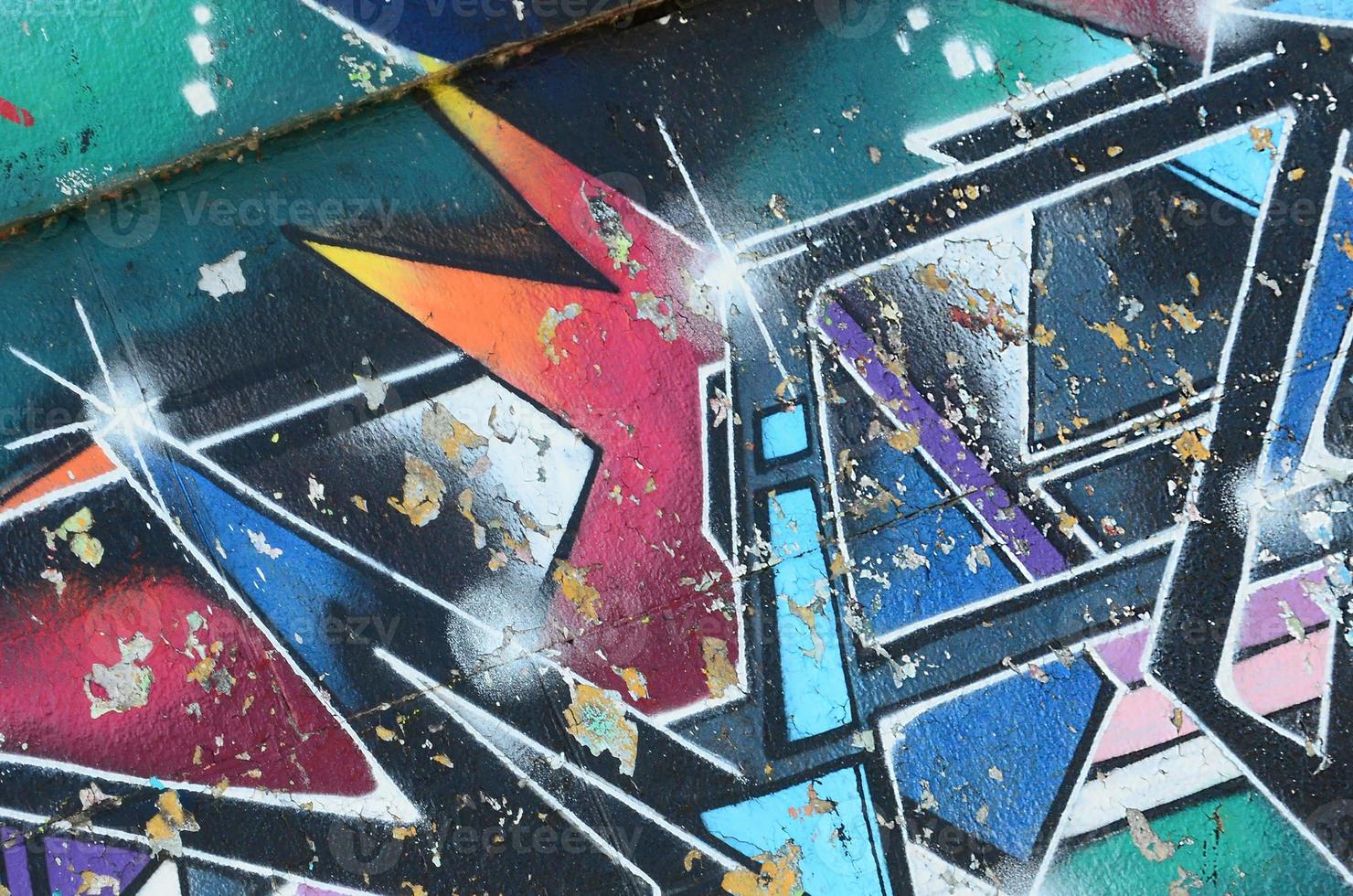 Fragment of graffiti drawings. The old wall decorated with paint stains in the style of street art culture. Multicolored background texture photo