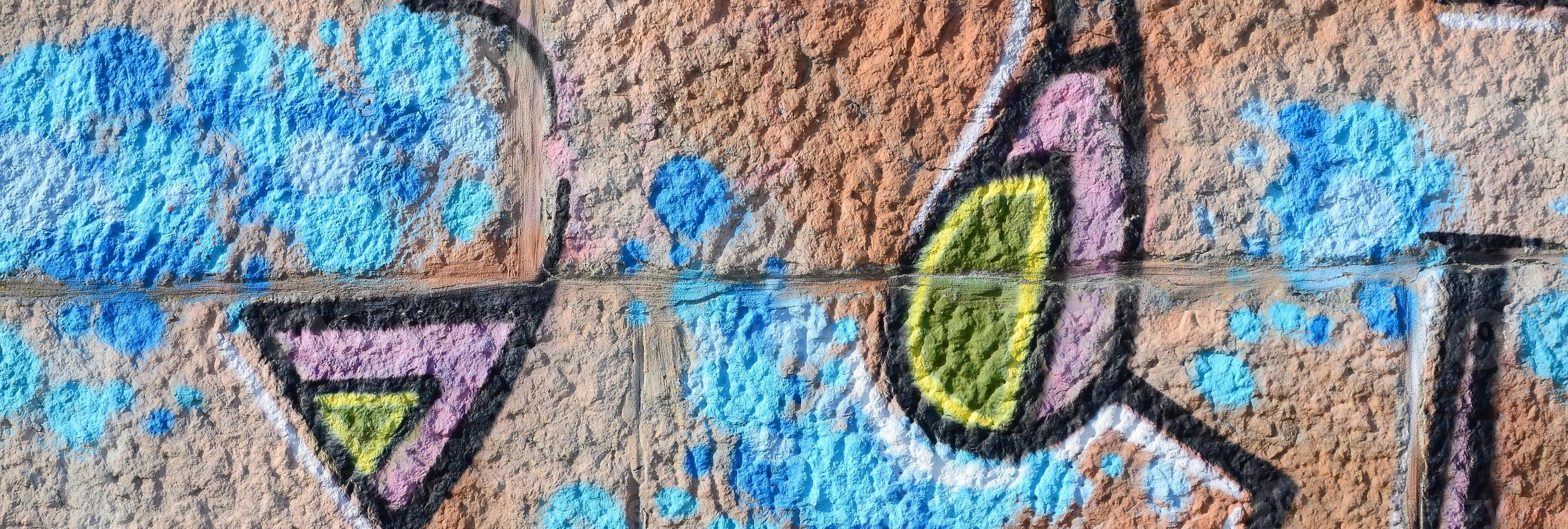 Fragment of graffiti drawings. The old wall decorated with paint stains in the style of street art culture. Colored background texture in warm tones photo