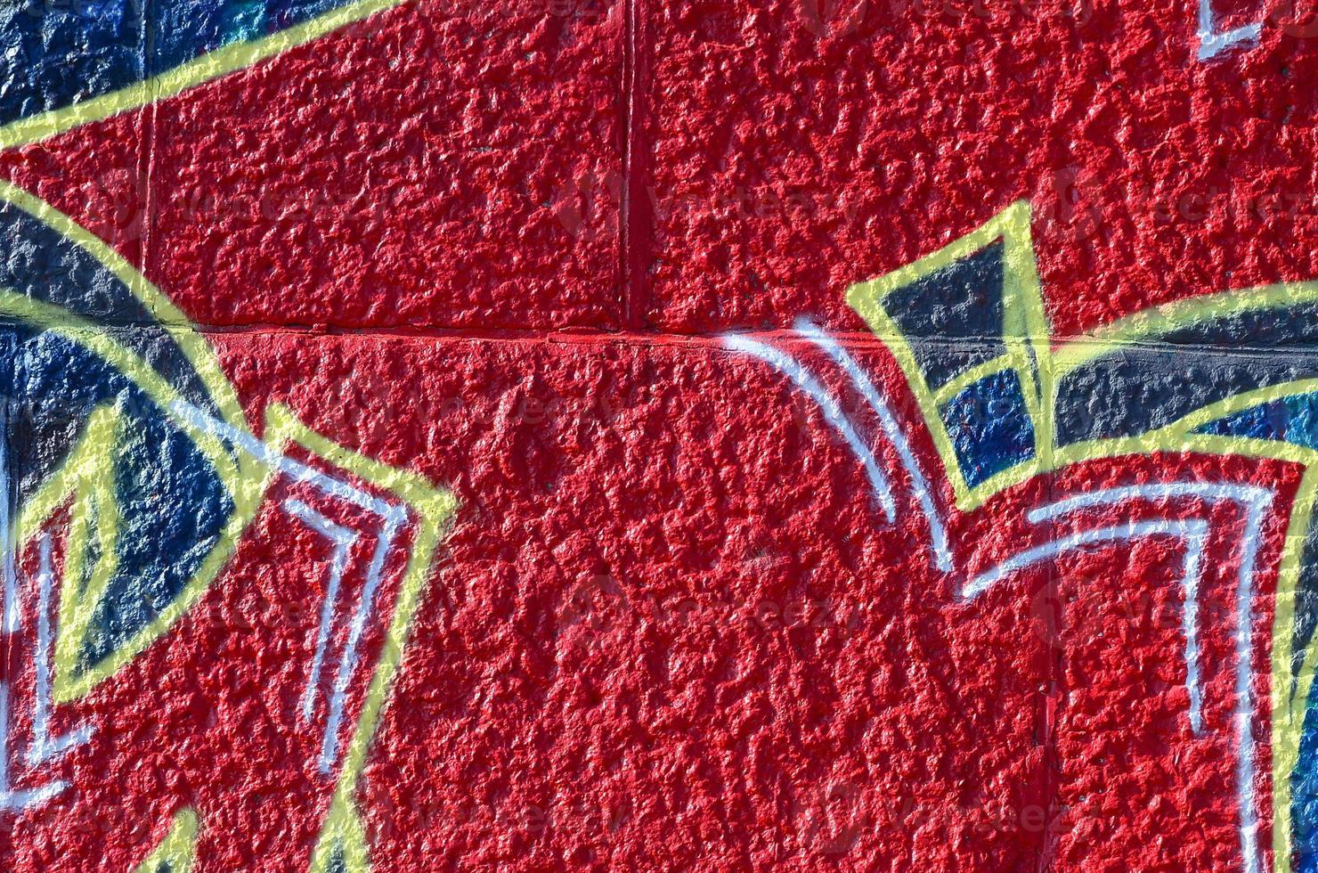 Fragment of graffiti drawings. The old wall decorated with paint stains in the style of street art culture. Colored background texture in warm tones photo
