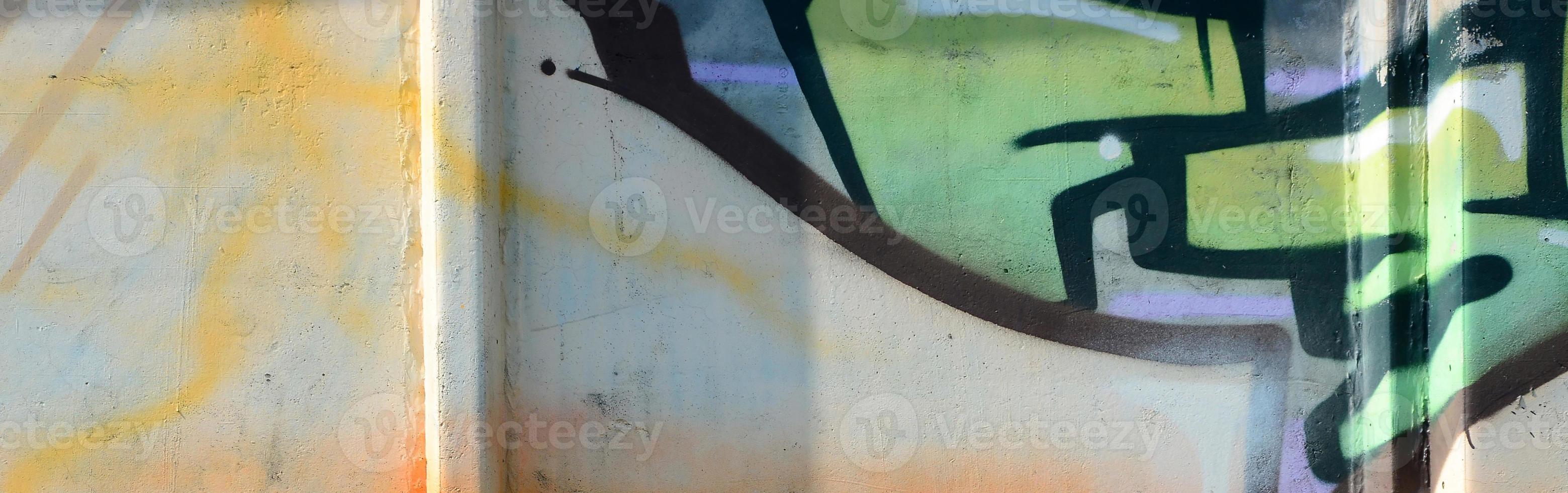 Fragment of graffiti drawings. The old wall decorated with paint stains in the style of street art culture. Colored background texture in warm tones photo