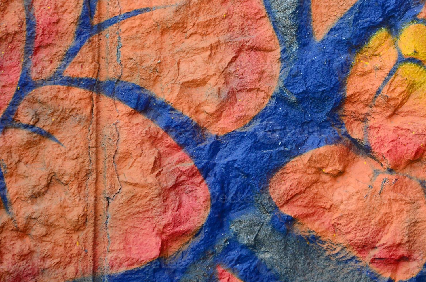 Fragment of graffiti drawings. The old wall decorated with paint stains in the style of street art culture. Orange flower photo
