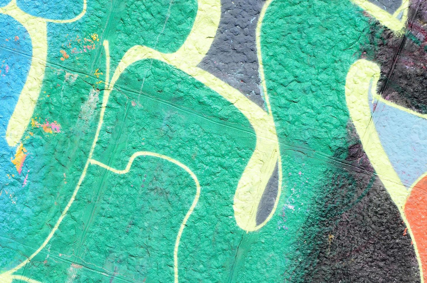 Fragment of graffiti drawings. The old wall decorated with paint stains in the style of street art culture. Colored background texture in green tones photo