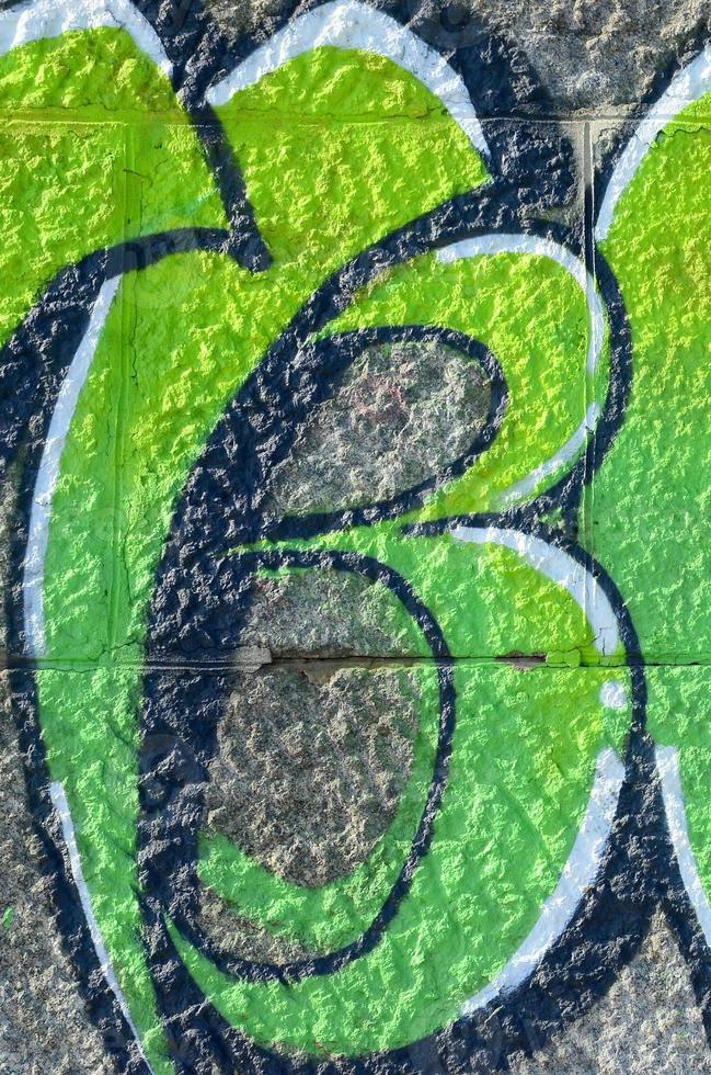 Fragment of graffiti drawings. The old wall decorated with paint stains in the style of street art culture. Colored background texture in green tones photo