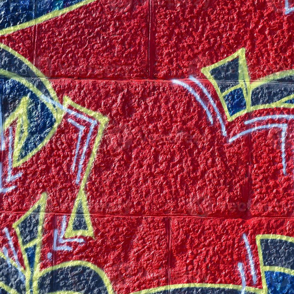 Fragment of graffiti drawings. The old wall decorated with paint stains in the style of street art culture. Colored background texture in warm tones photo