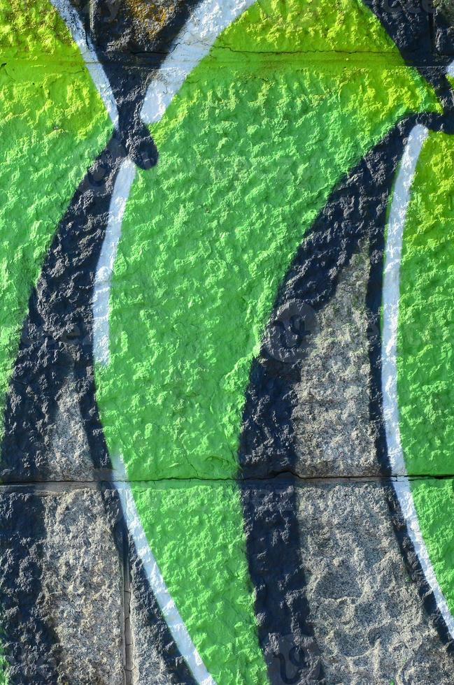 Fragment of graffiti drawings. The old wall decorated with paint stains in the style of street art culture. Colored background texture in green tones photo