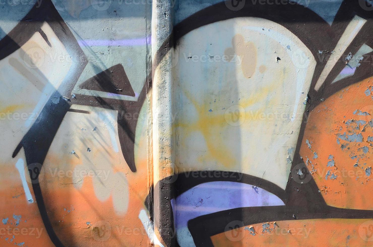 Fragment of graffiti drawings. The old wall decorated with paint stains in the style of street art culture. Colored background texture in warm tones photo