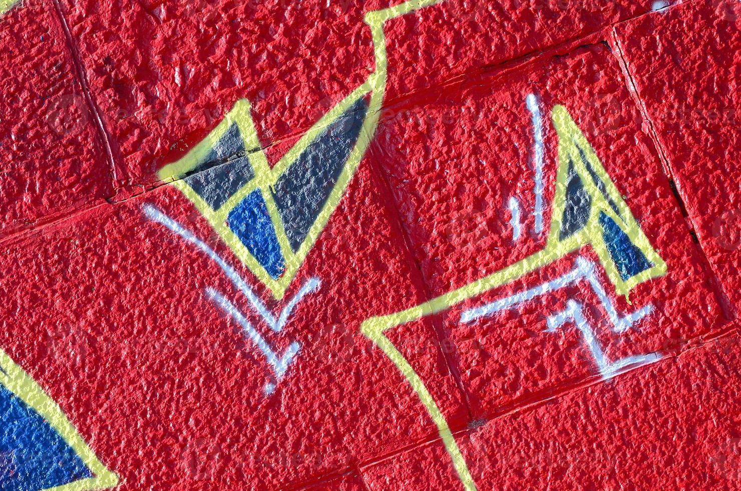 Fragment of graffiti drawings. The old wall decorated with paint stains in the style of street art culture. Colored background texture in warm tones photo