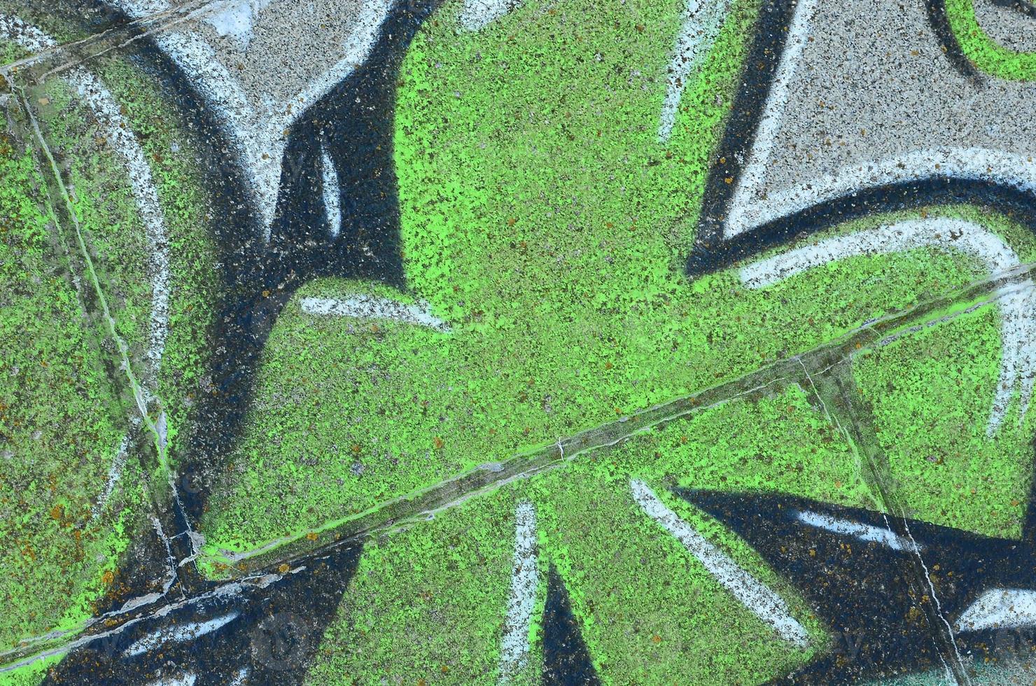 Fragment of graffiti drawings. The old wall decorated with paint stains in the style of street art culture. Colored background texture in green tones photo