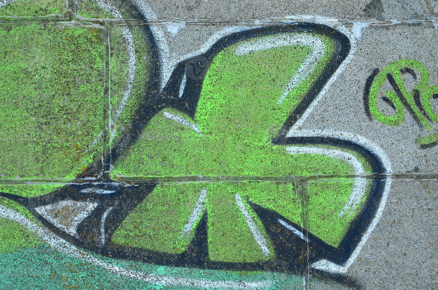 Fragment of graffiti drawings. The old wall decorated with paint stains in the style of street art culture. Colored background texture in green tones photo