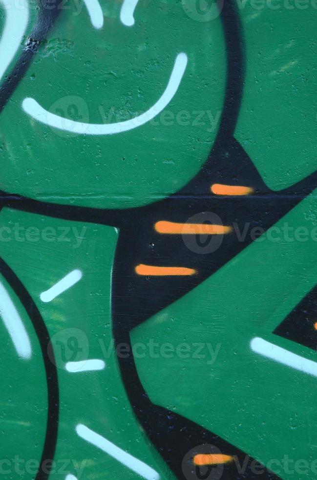 Fragment of graffiti drawings. The old wall decorated with paint stains in the style of street art culture. Colored background texture in green tones photo