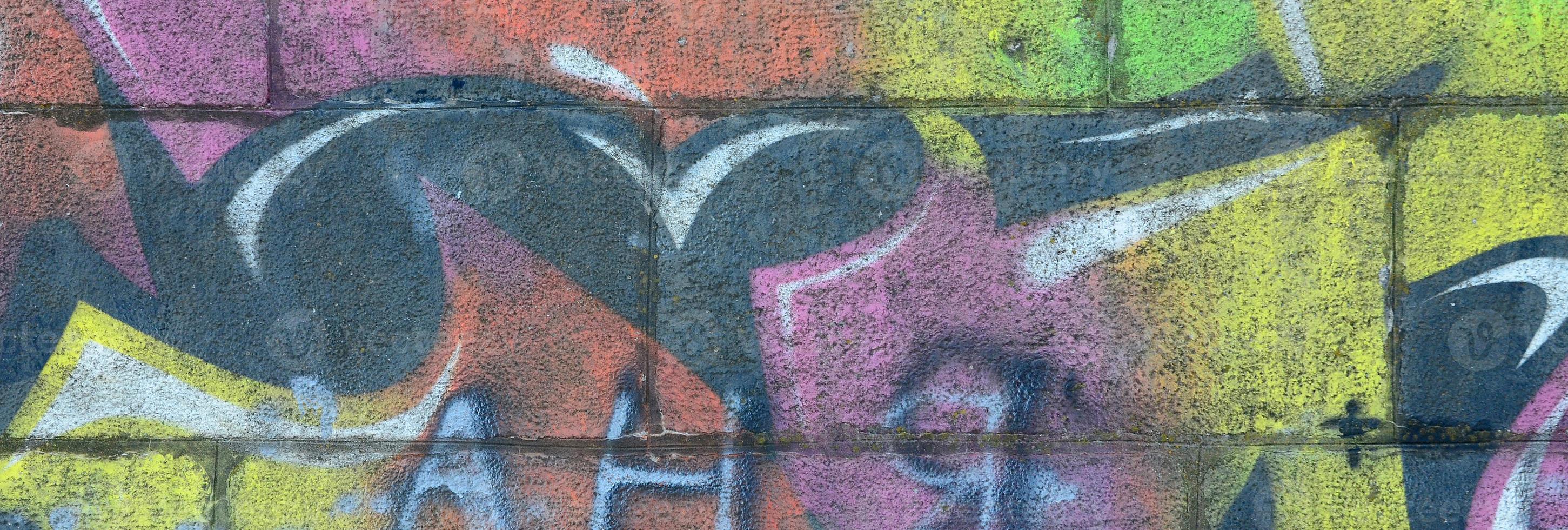 Fragment of graffiti drawings. The old wall decorated with paint stains in the style of street art culture. Multicolored background texture photo