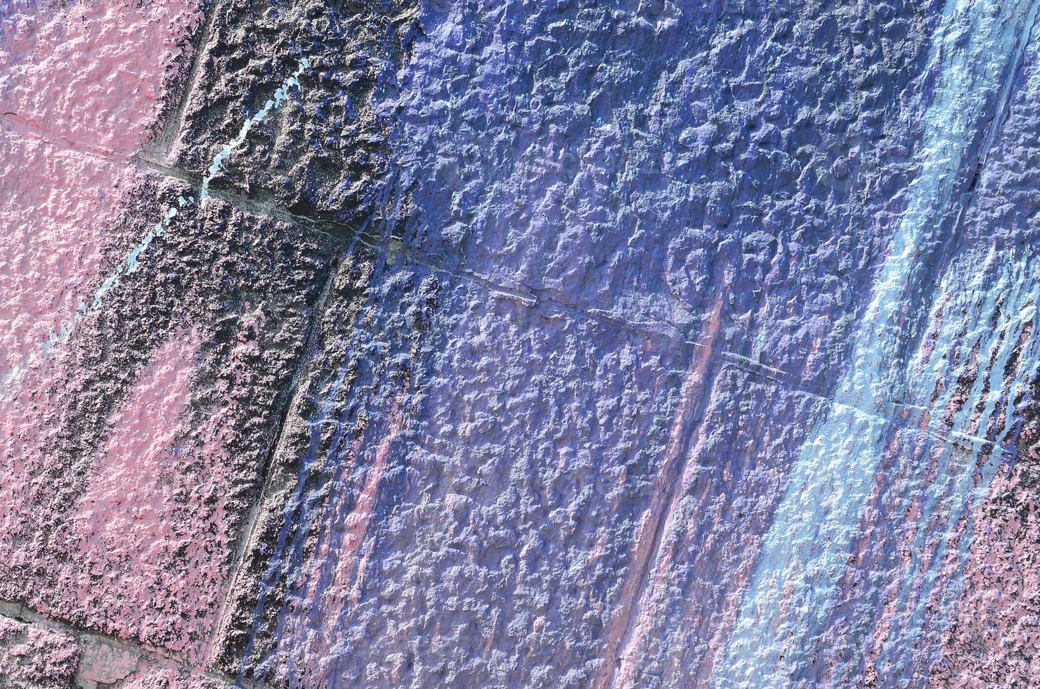 Fragment of graffiti drawings. The old wall decorated with paint stains in the style of street art culture. Colored background texture in purple tones photo