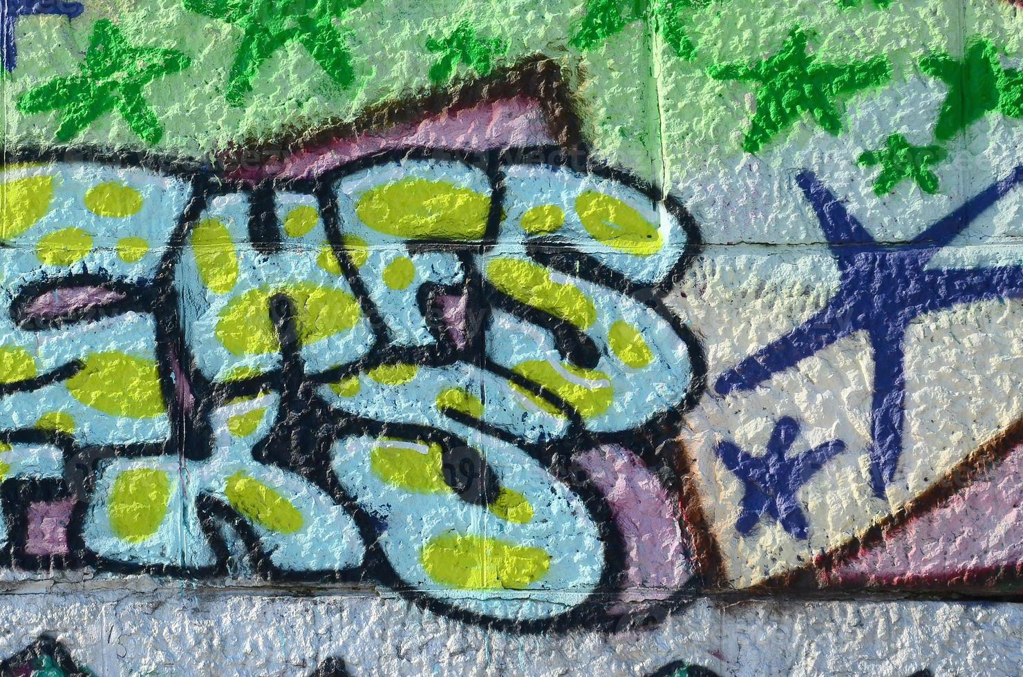 Fragment of graffiti drawings. The old wall decorated with paint stains in the style of street art culture. Colored background texture in green tones photo