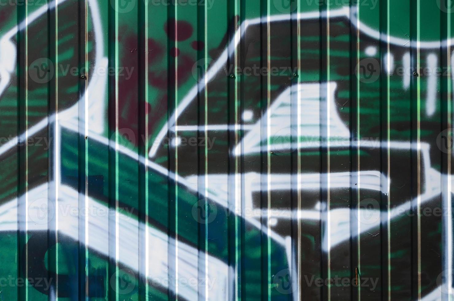 fragmento de dibujos de graffiti. la antigua muralla decorada con manchas de pintura al estilo de la cultura del arte callejero. textura de fondo coloreada en tonos verdes foto