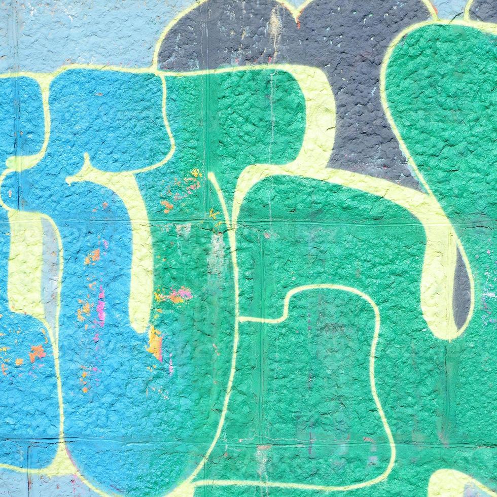 Fragment of graffiti drawings. The old wall decorated with paint stains in the style of street art culture. Colored background texture in green tones photo