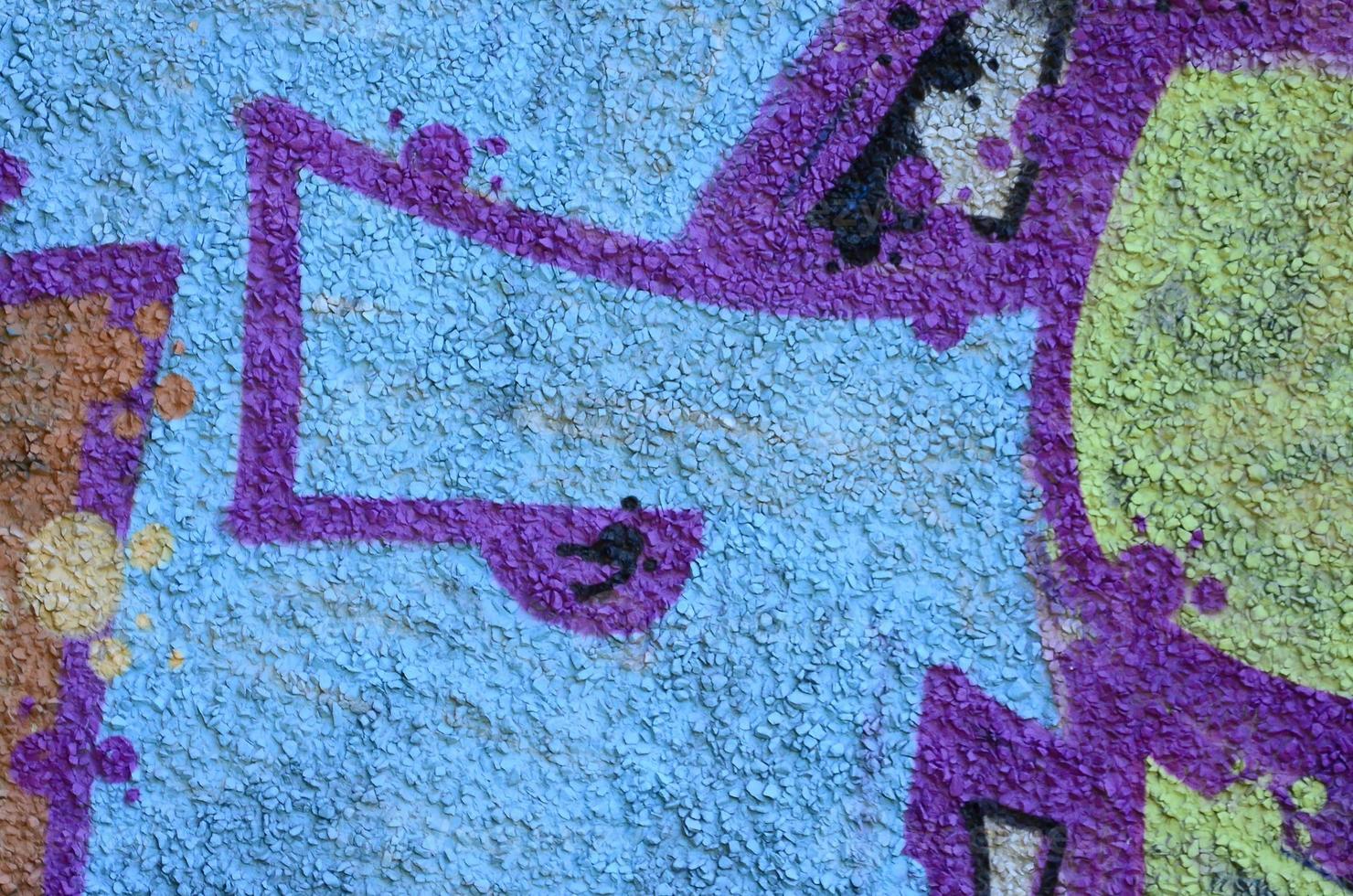 Fragment of graffiti drawings. The old wall decorated with paint stains in the style of street art culture. Colored background texture in warm tones photo