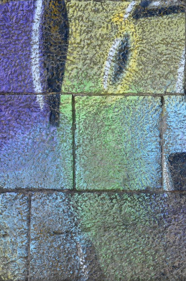Fragment of graffiti drawings. The old wall decorated with paint stains in the style of street art culture. Multicolored background texture photo