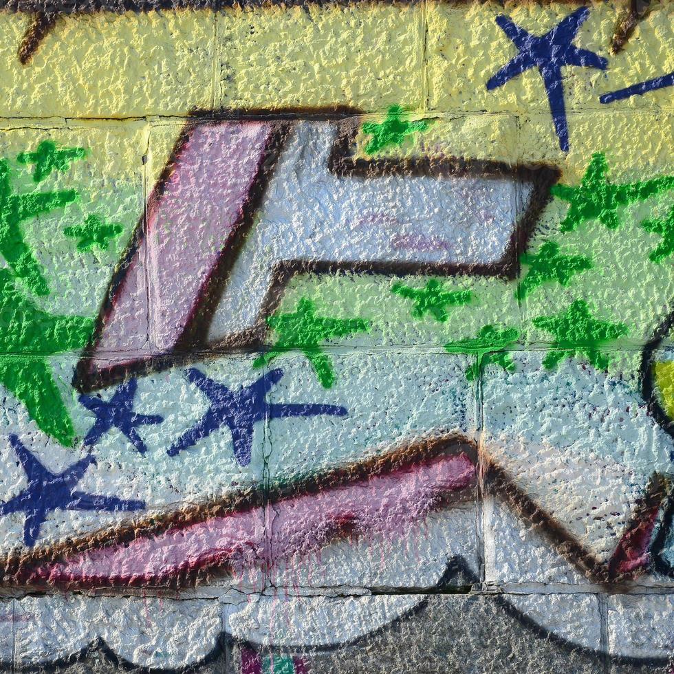 Fragment of graffiti drawings. The old wall decorated with paint stains in the style of street art culture. Colored background texture in green tones photo