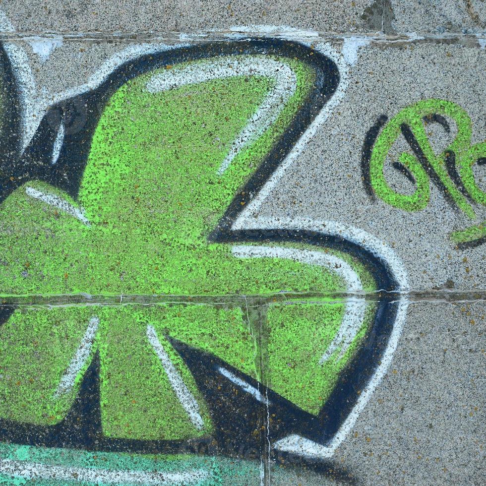 Fragment of graffiti drawings. The old wall decorated with paint stains in the style of street art culture. Colored background texture in green tones photo