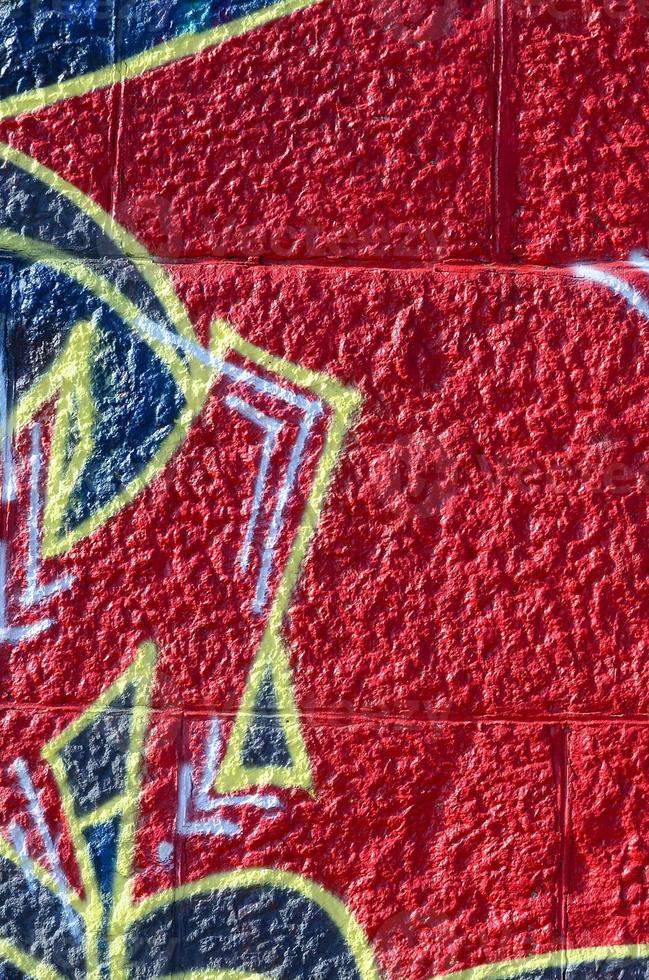 fragmento de dibujos de graffiti. la antigua muralla decorada con manchas de pintura al estilo de la cultura del arte callejero. textura de fondo coloreada en tonos cálidos foto