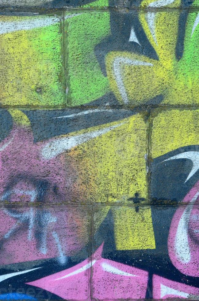 Fragment of graffiti drawings. The old wall decorated with paint stains in the style of street art culture. Multicolored background texture photo