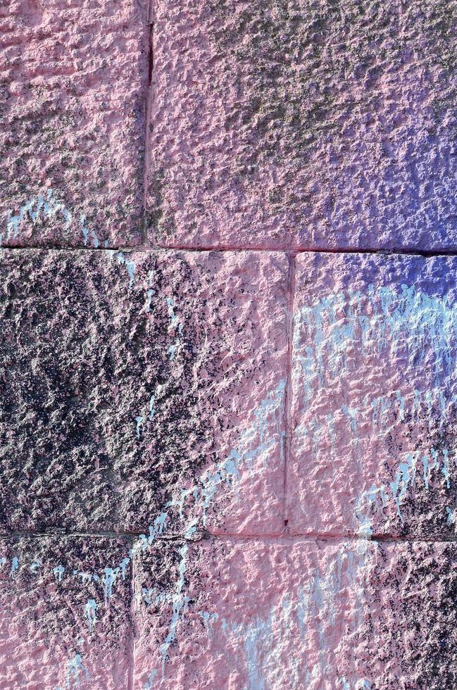 Fragment of graffiti drawings. The old wall decorated with paint stains in the style of street art culture. Colored background texture in purple tones photo