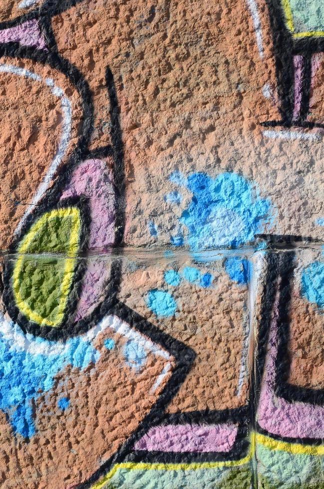 Fragment of graffiti drawings. The old wall decorated with paint stains in the style of street art culture. Colored background texture in warm tones photo
