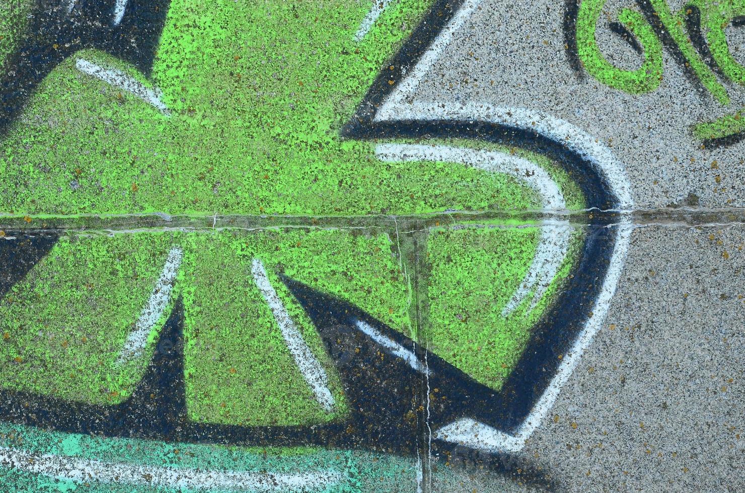 Fragment of graffiti drawings. The old wall decorated with paint stains in the style of street art culture. Colored background texture in green tones photo