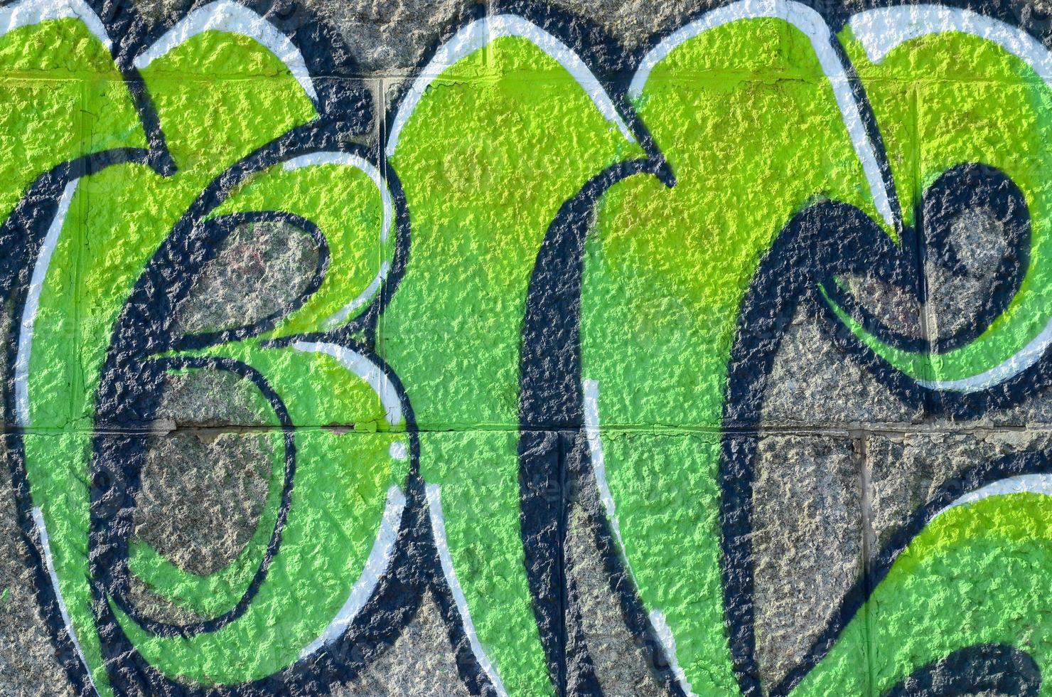 Fragment of graffiti drawings. The old wall decorated with paint stains in the style of street art culture. Colored background texture in green tones photo