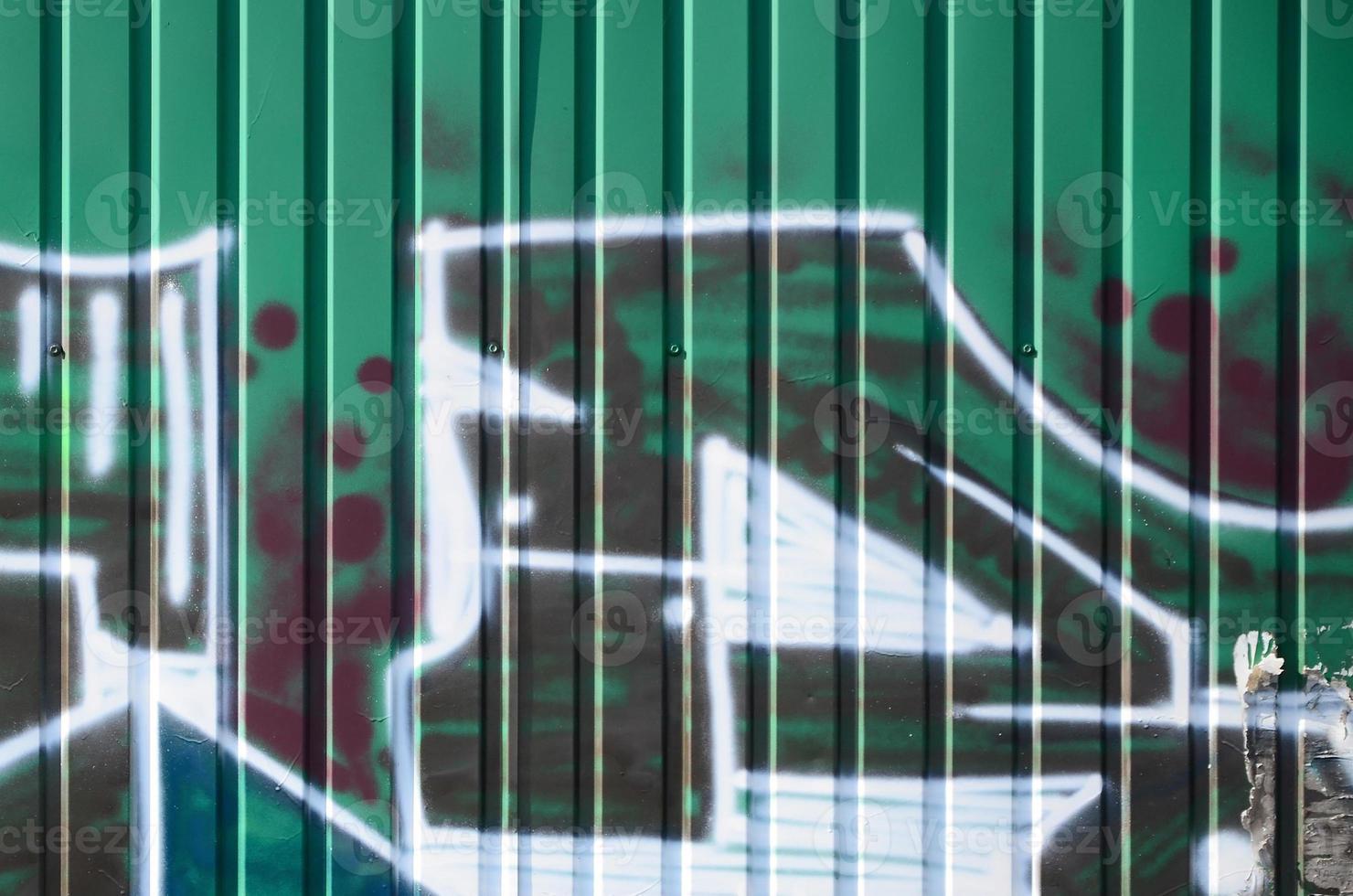 Fragment of graffiti drawings. The old wall decorated with paint stains in the style of street art culture. Colored background texture in green tones photo