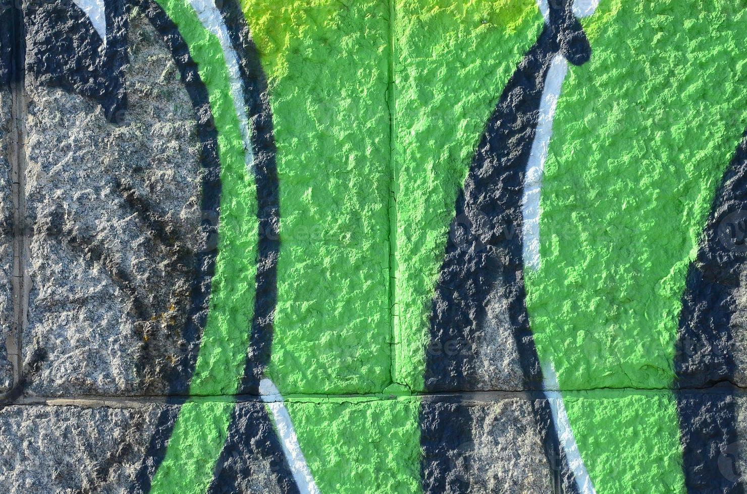 Fragment of graffiti drawings. The old wall decorated with paint stains in the style of street art culture. Colored background texture in green tones photo