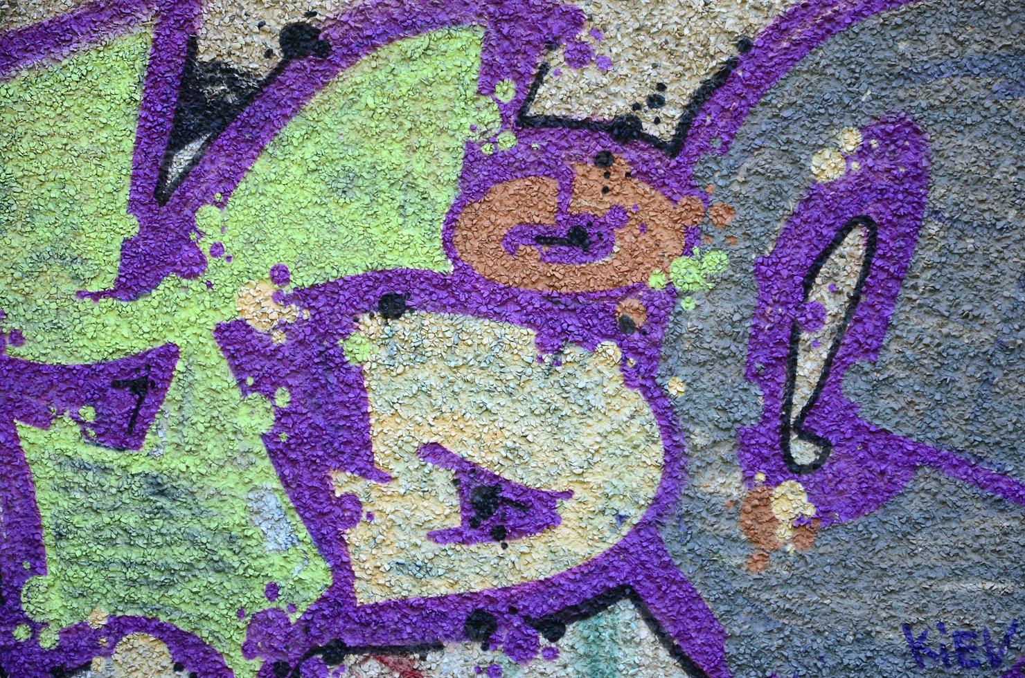 Fragment of graffiti drawings. The old wall decorated with paint stains in the style of street art culture. Colored background texture in warm tones photo