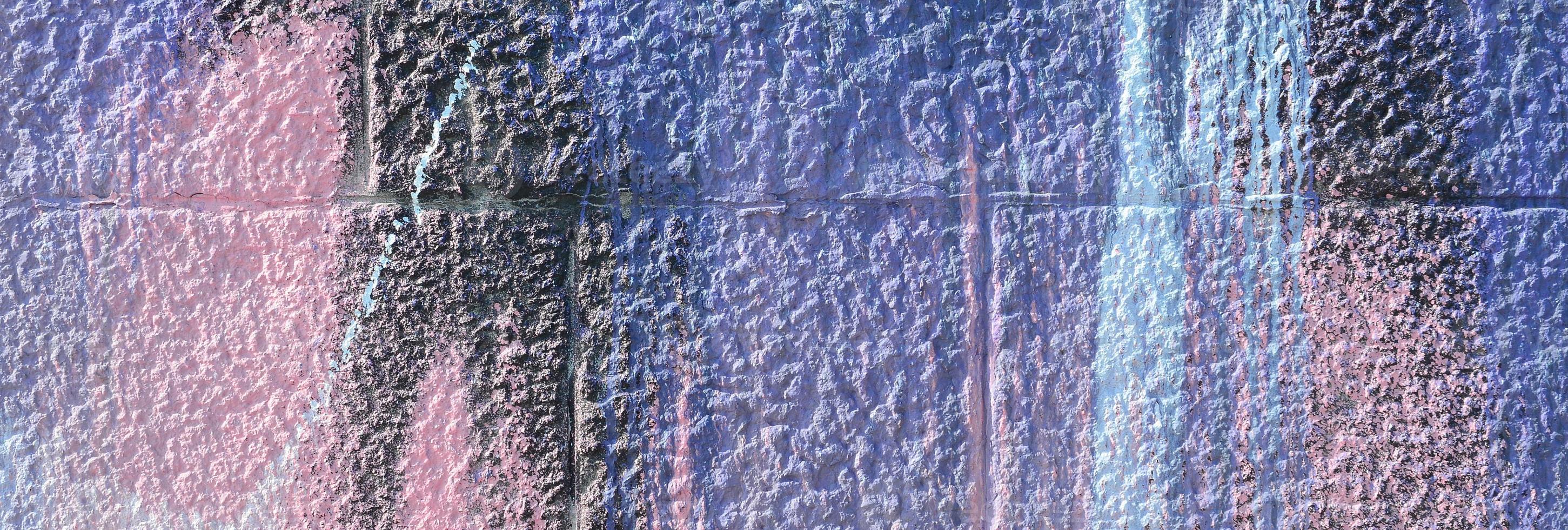 Fragment of graffiti drawings. The old wall decorated with paint stains in the style of street art culture. Colored background texture in purple tones photo