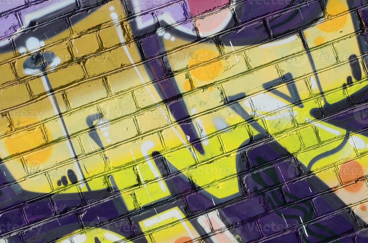 Fragment of graffiti drawings. The old wall decorated with paint stains in the style of street art culture. Colored background texture in warm tones photo