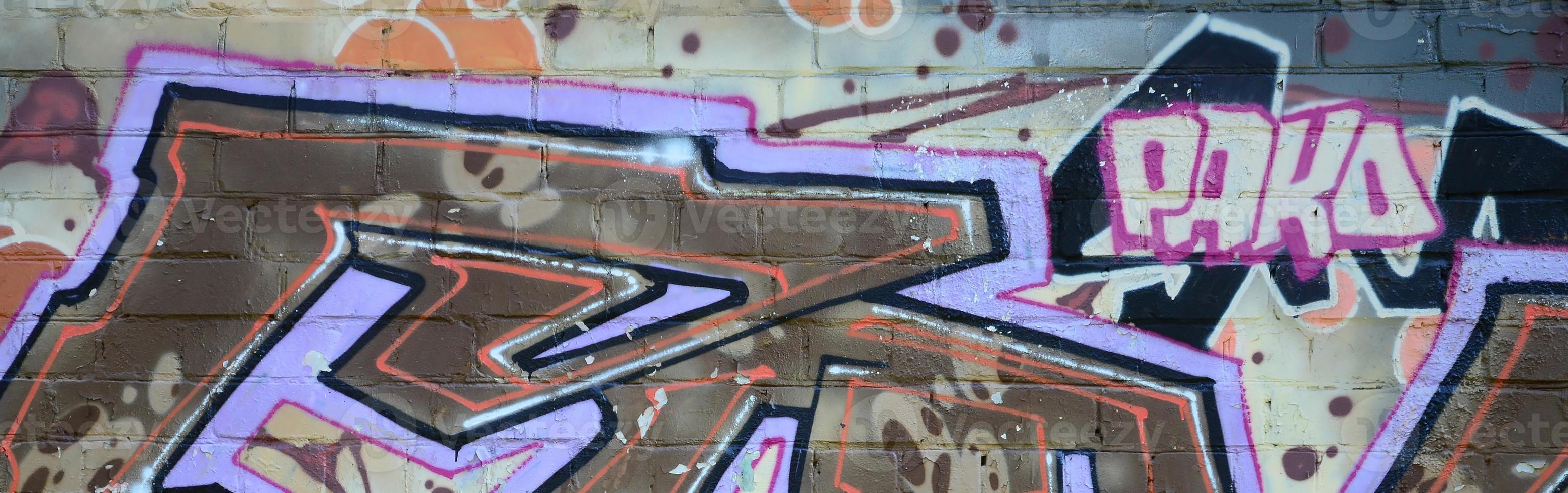 Fragment of graffiti drawings. The old wall decorated with paint stains in the style of street art culture. Colored background texture in warm tones photo